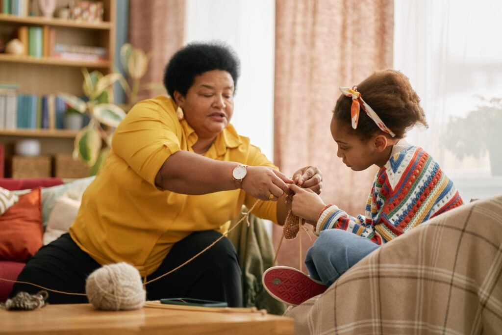 senior-black-woman-teaching-knitting-to-young-chil-2025-06-06-02-30-14-utc (1)